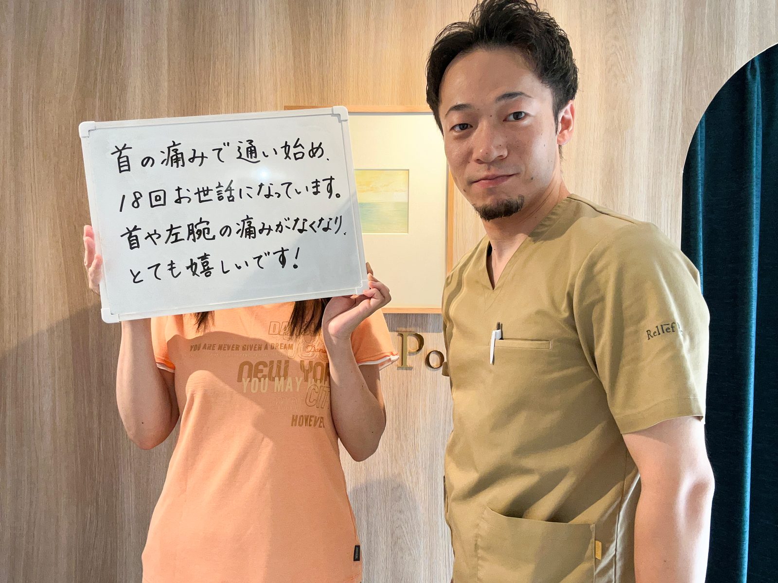 メッセージを書いたホワイトボードを持つ患者さまと院長