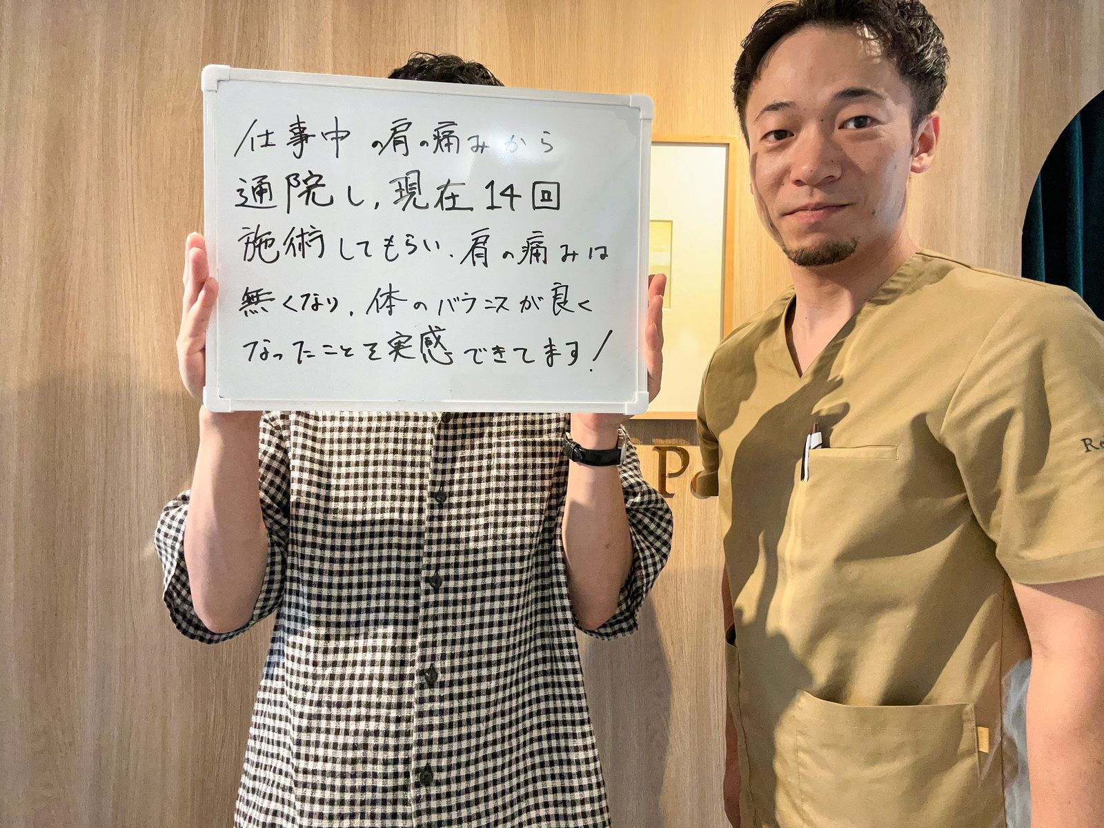メッセージを書いたホワイトボードを持つ患者さまと院長