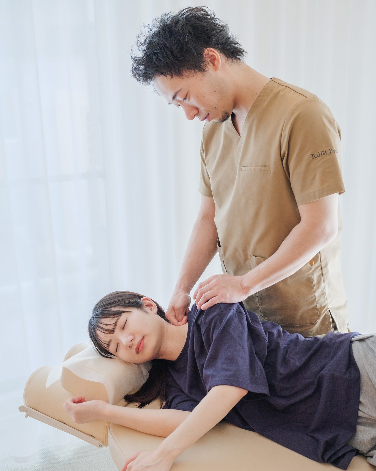 横になった患者さまの首・肩まわりへの施術