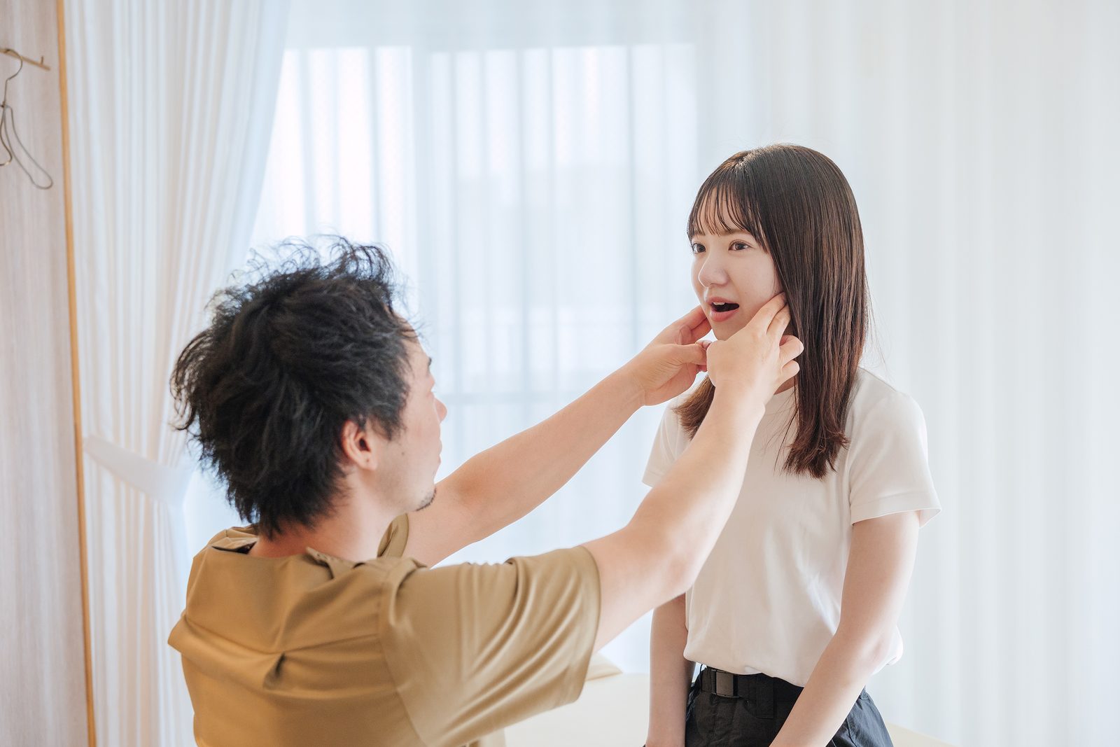 立った姿勢で、顎や首まわりの動きを確認している様子