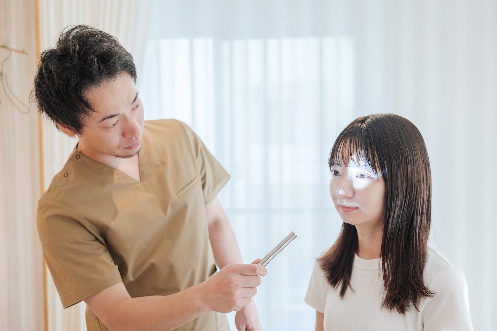 ペンライトを使って、目の動き(視線)を確認している様子